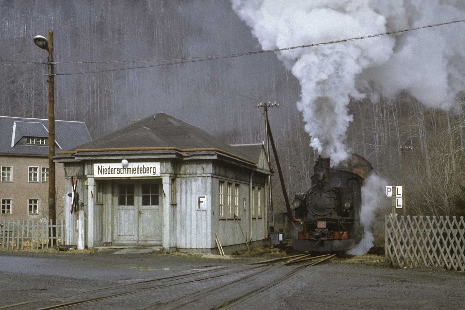 99 1582 am Stationsgebäude Niederschmiedeberg Schmalspurzug an Station