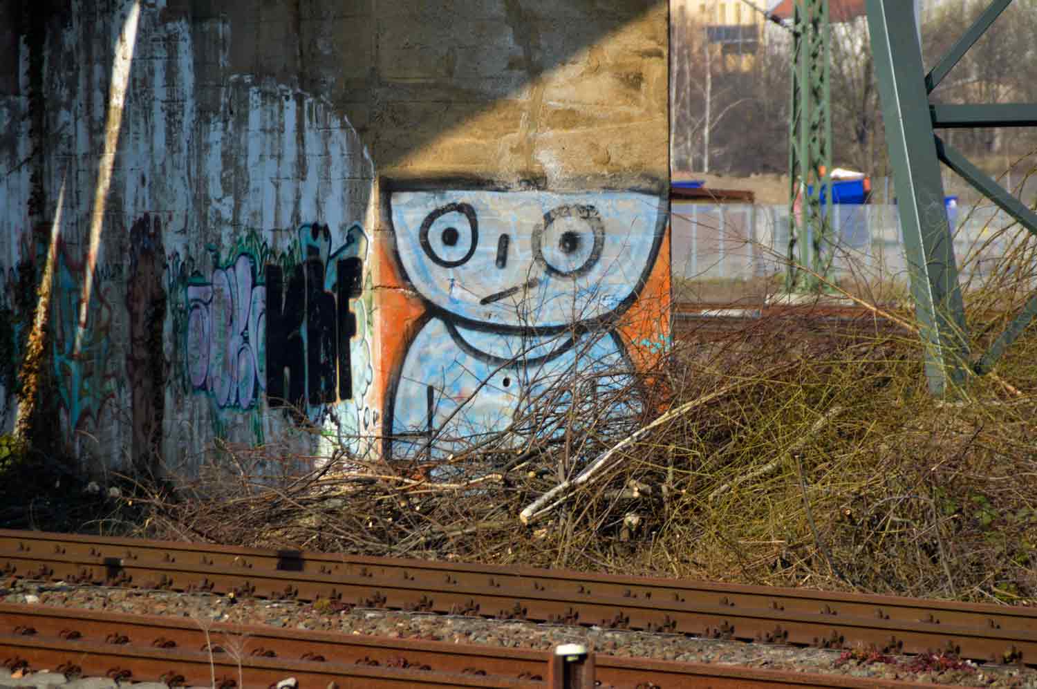 Ein Schüsselkopf-Männchen an der ehemaligen Bahnbrücke von Anschlussgleis PX Graffiti an Eisenbahnbrücke