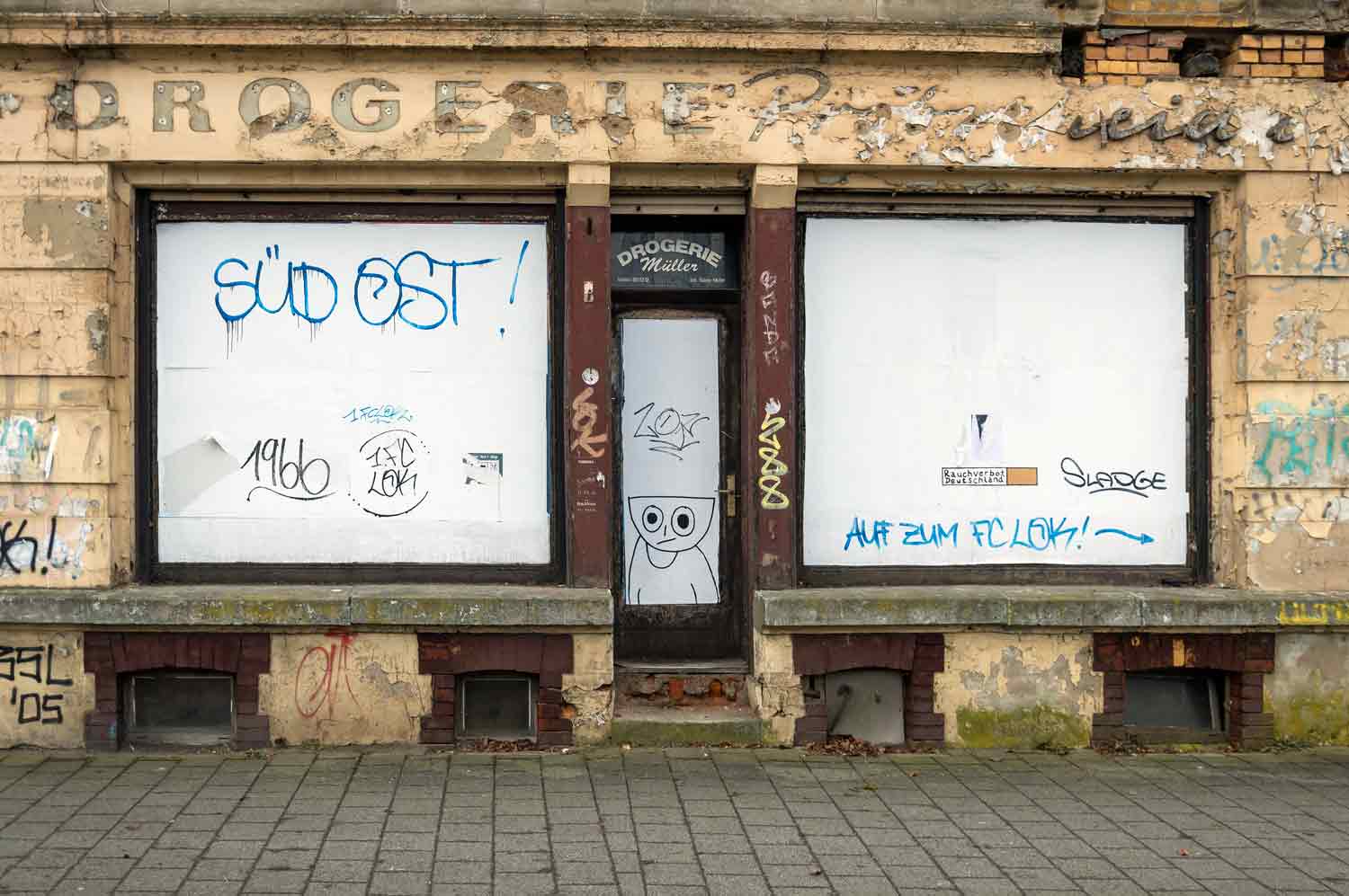 Schüsselkopf-Männchen an geschlossener Drogerie Prager Straße Fenster-Zeichnung