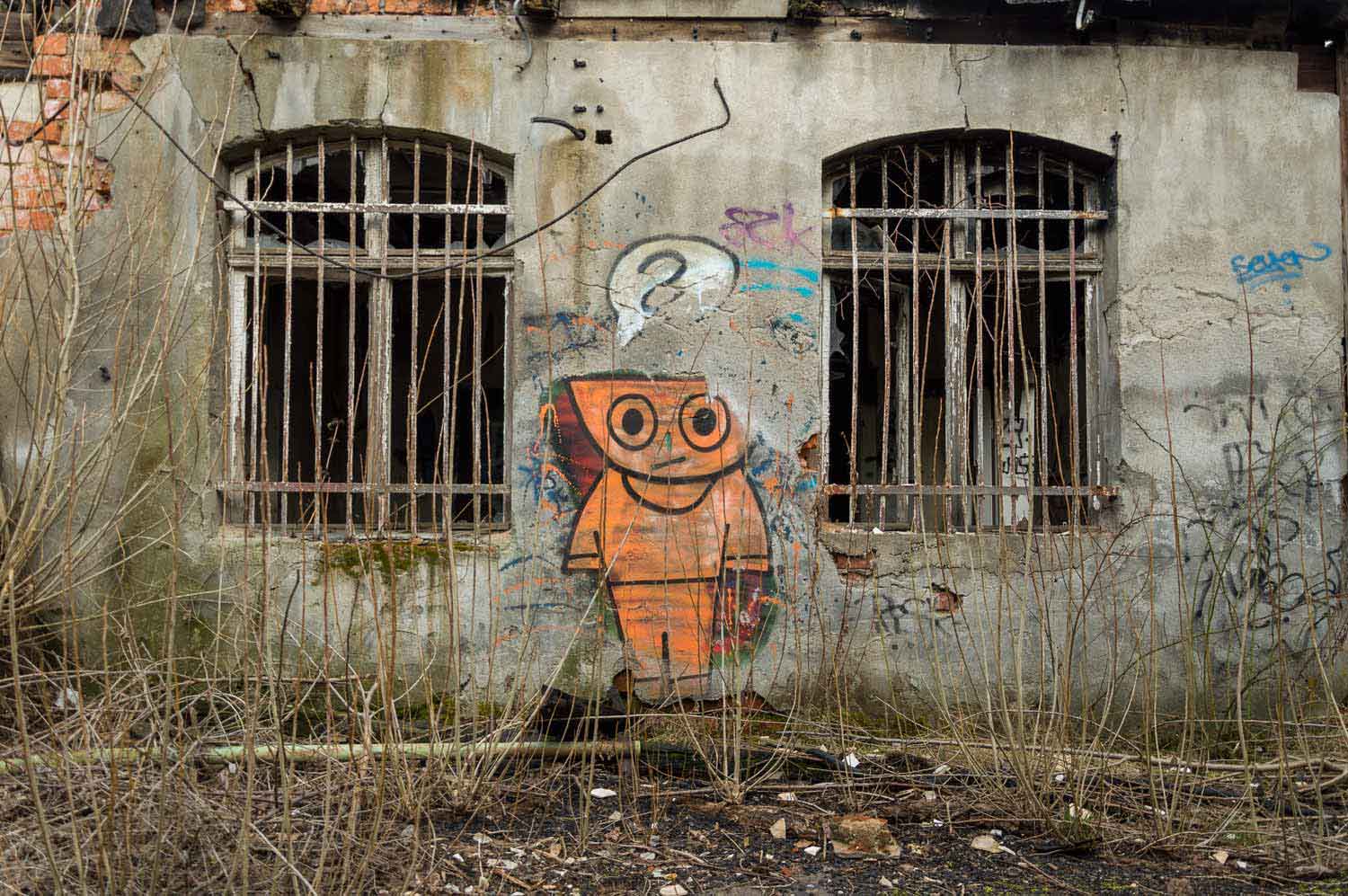 Verloren wirkt das Schüsselkopf-Männchen bei Gurken-Schumann Graffiti bei Gurken-Schumann