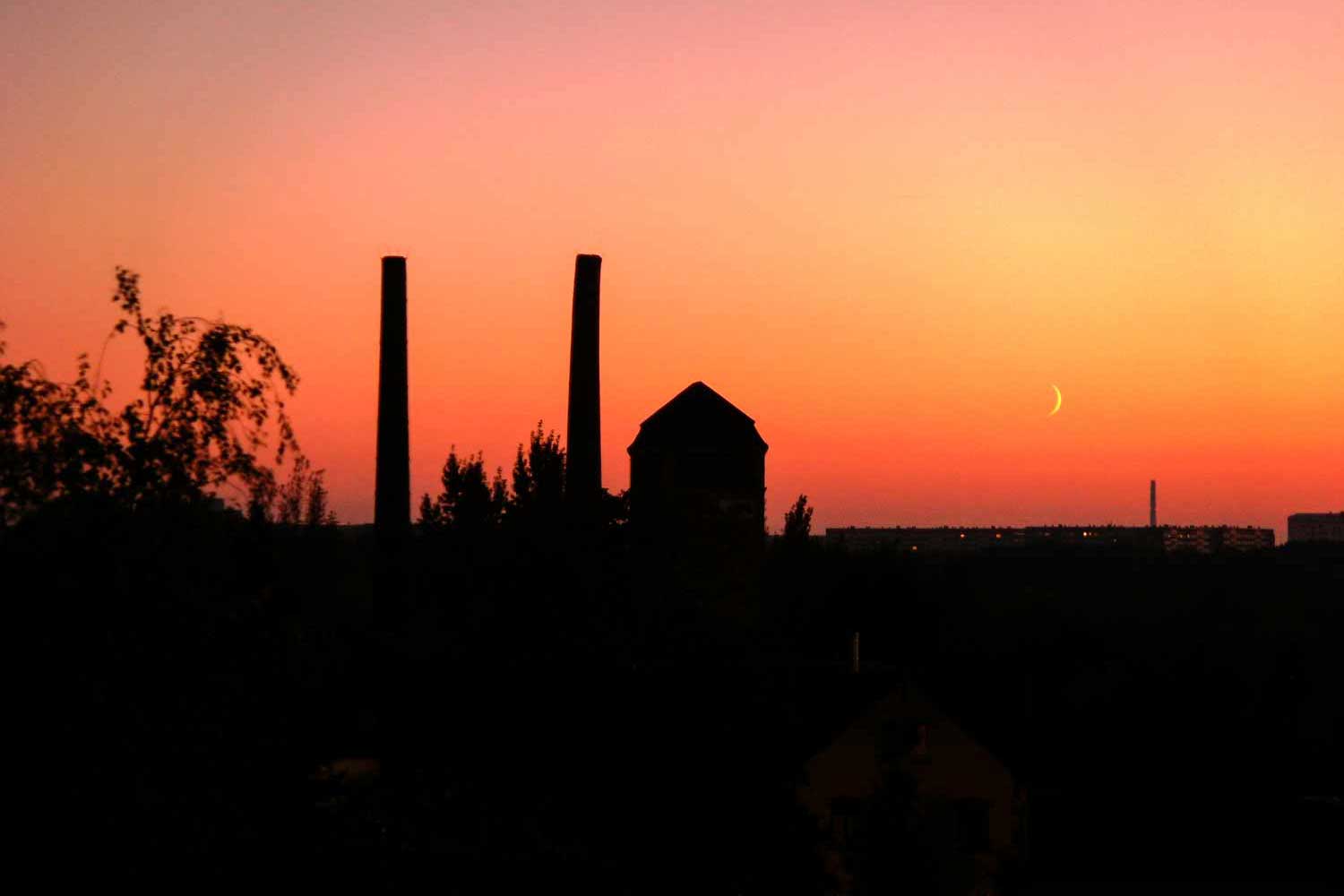 Sonnenuntergang mit Schornsteinen der Bäckerei am Lindenauer Hafen Sonnenuntergang über Industriebrache