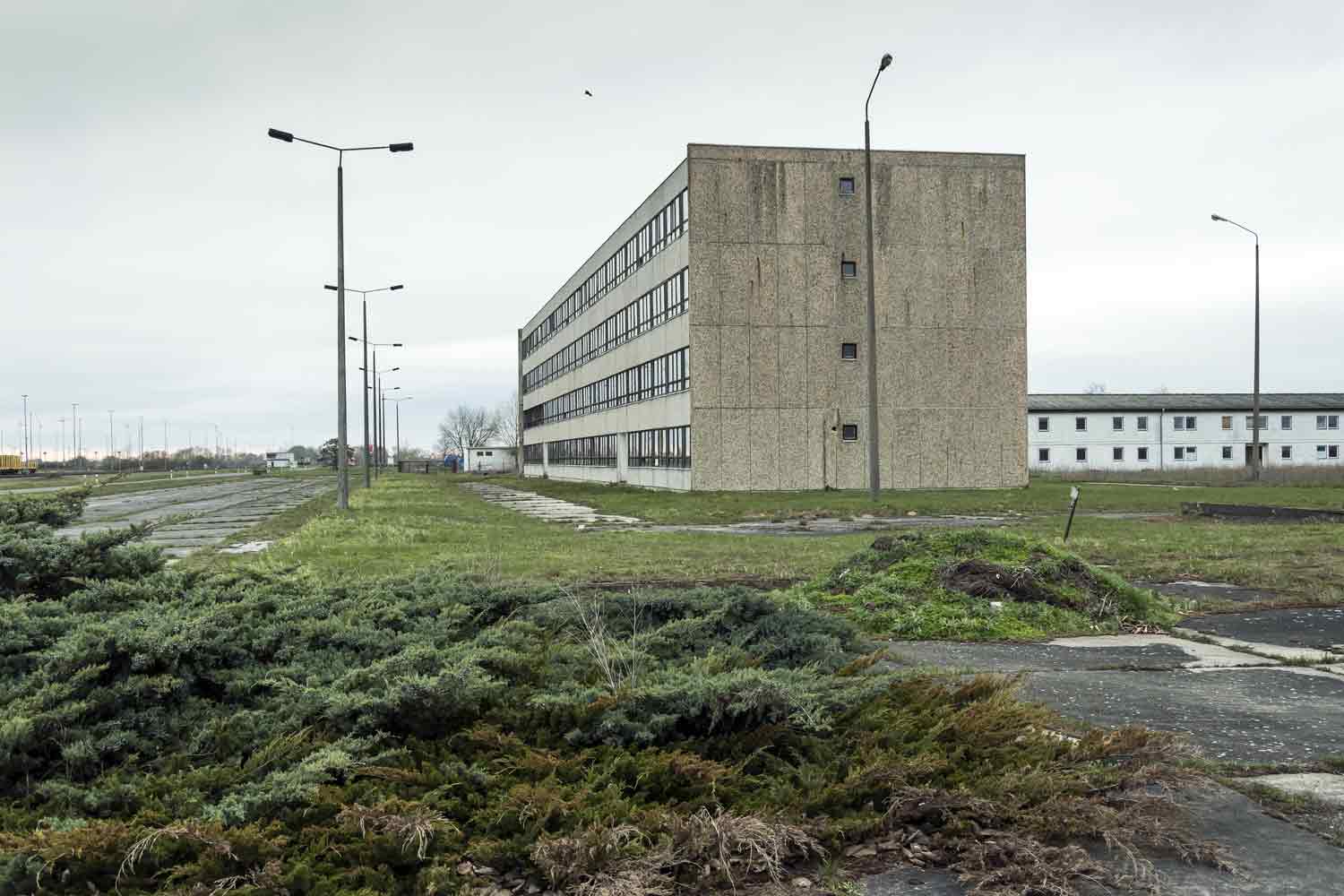 Nebengebäude der Baustelle haben den Abriss des Kraftwerkes überstanden Plattenbau-Block