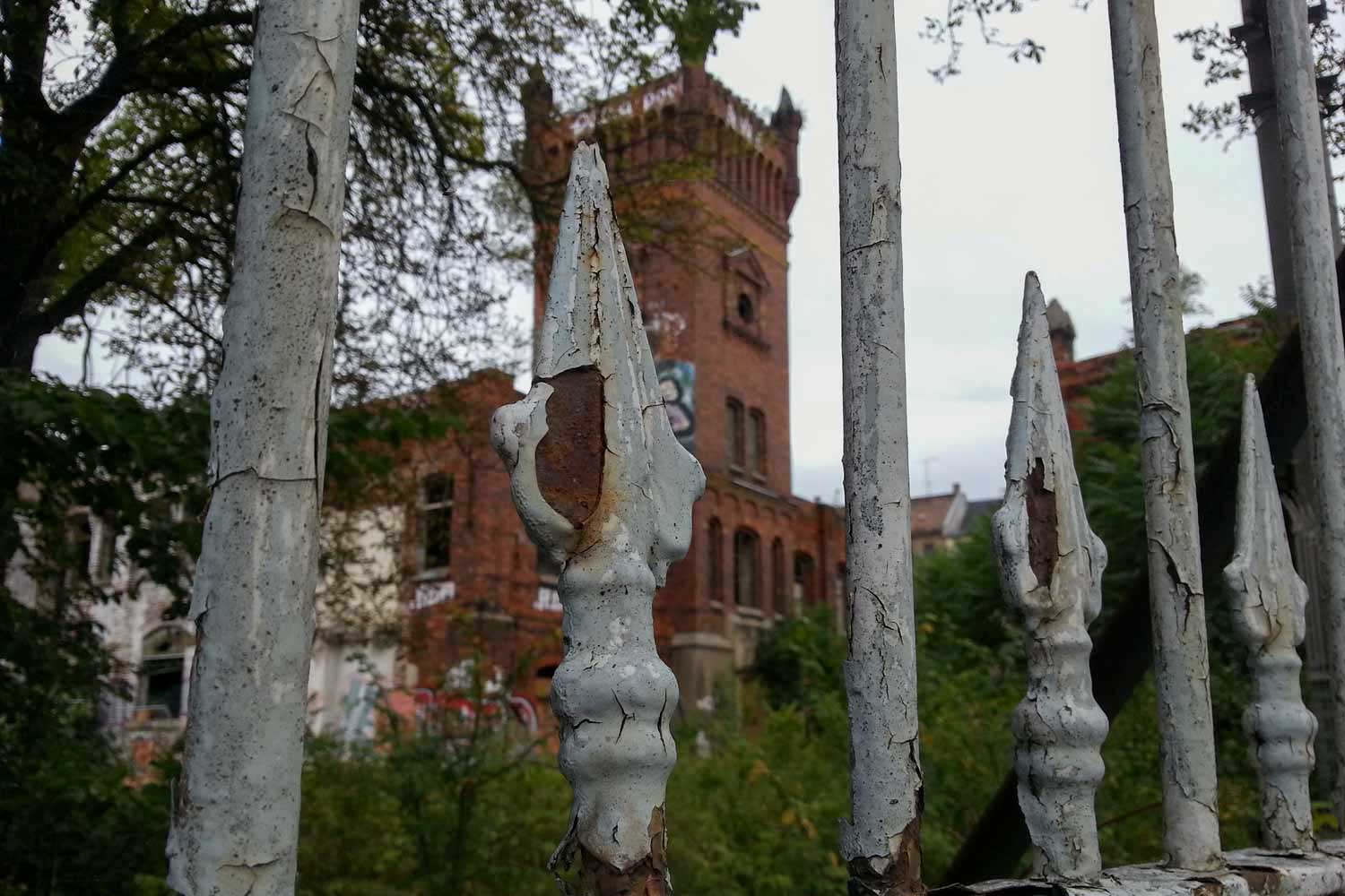 Swiderski-Gebäudeensemble mit Wasserturm Ruine hinter Zaun