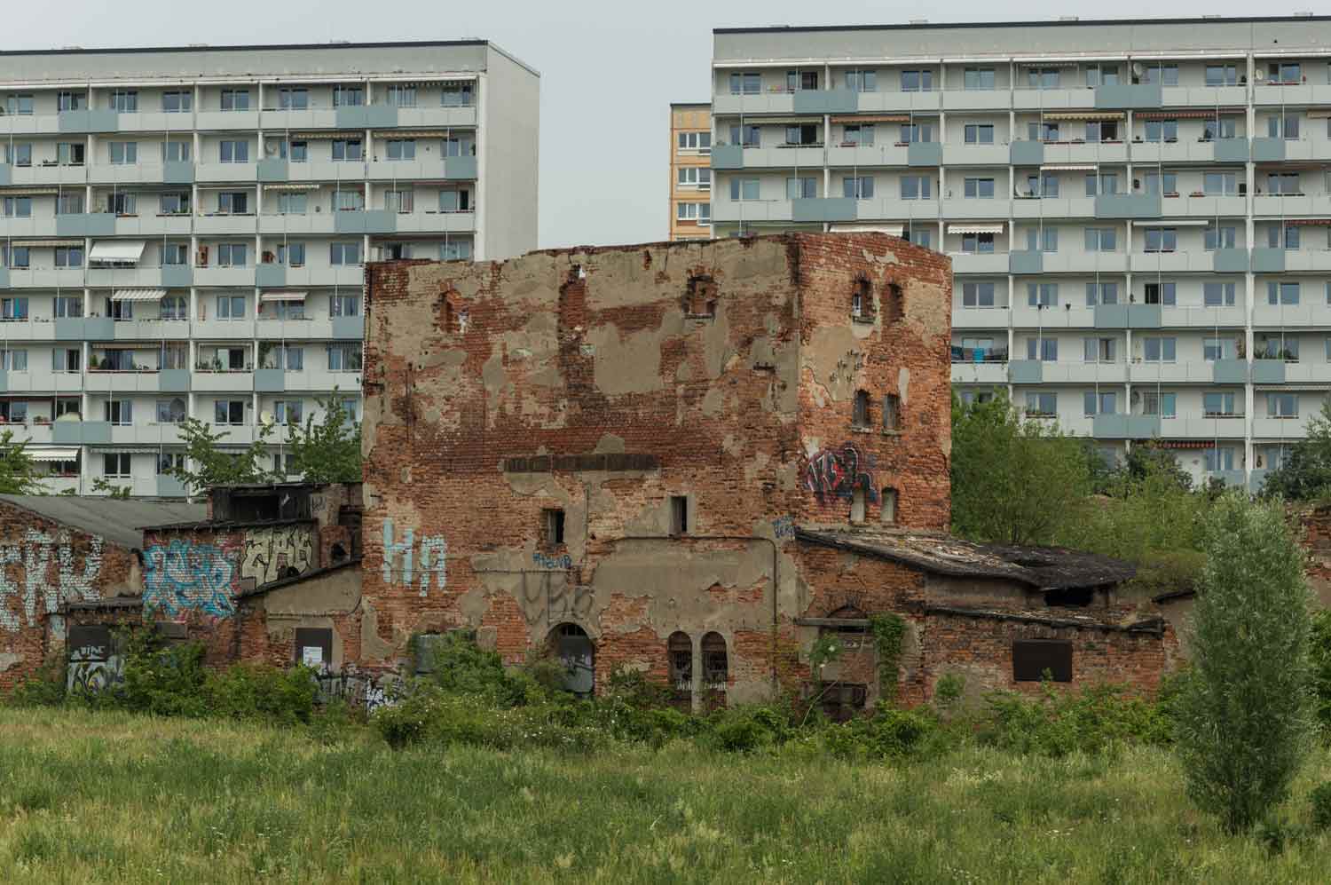 Alt und neu in nächster Nähe des Neubau-Wohnkomplexes Ruinen vor Neubaufront