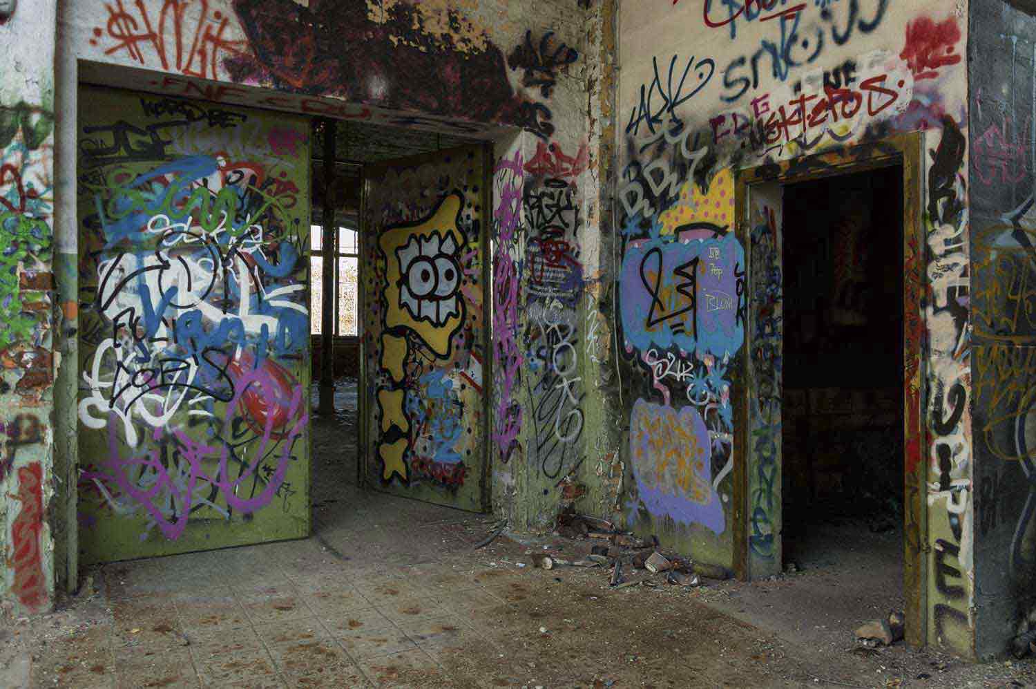 Das Gebäudeinnere zieren zahllose Graffitis Bunte Graffitis an Türen