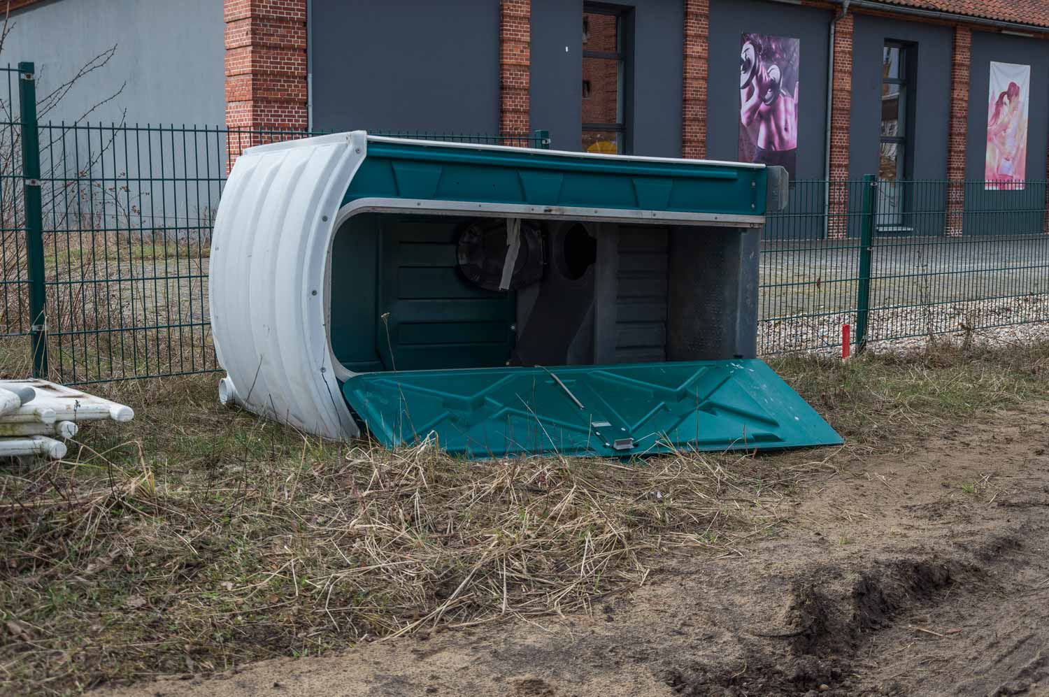 Umgestürztes Toilettenhäuschen auf einer Baustelle Umgekipptes Toilettenhäuschen