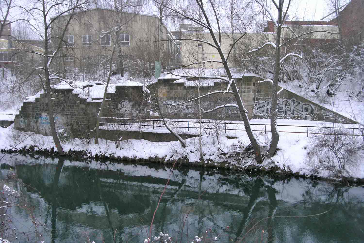 Reste der Widerlager der kriegszerstörten Kanalbrücke am Mörtelwerk Verschneites Brücken-Widerlager